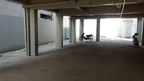 Eine leere Tiefgarage mit Betonsäulen und einem Motorrad in der Ferne.