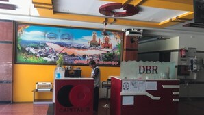 A reception desk with a large mural of a cityscape and a woman standing behind it.