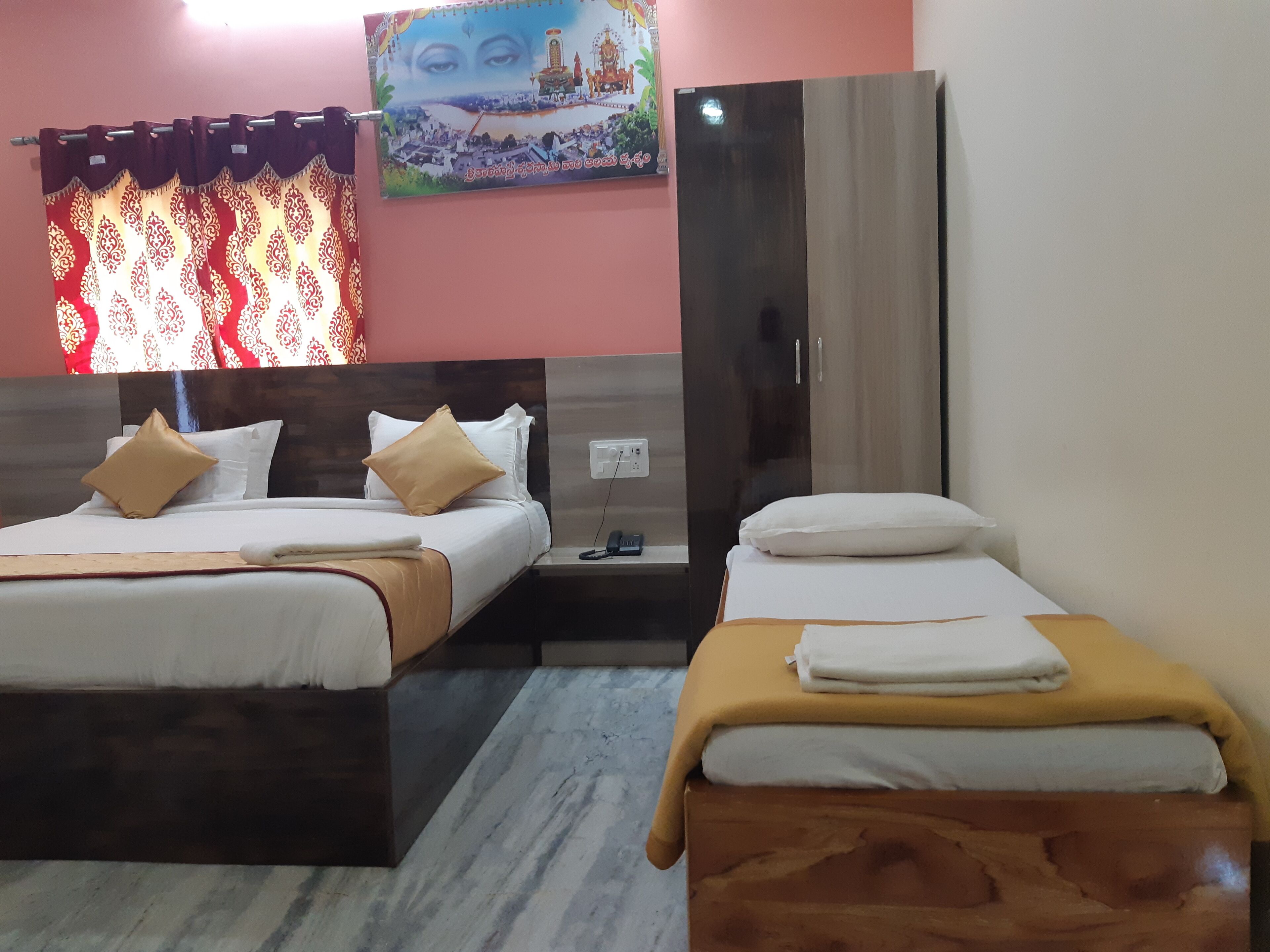 A hotel room with two beds, a wardrobe, a nightstand, and a wall with a painting.