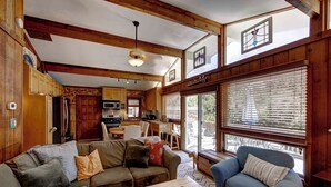 A cozy cabin interior with a wooden ceiling, a dining area, and a living room with a sofa and armchairs. - Sandy Pause - Ocracoke Island (Ocracoke)