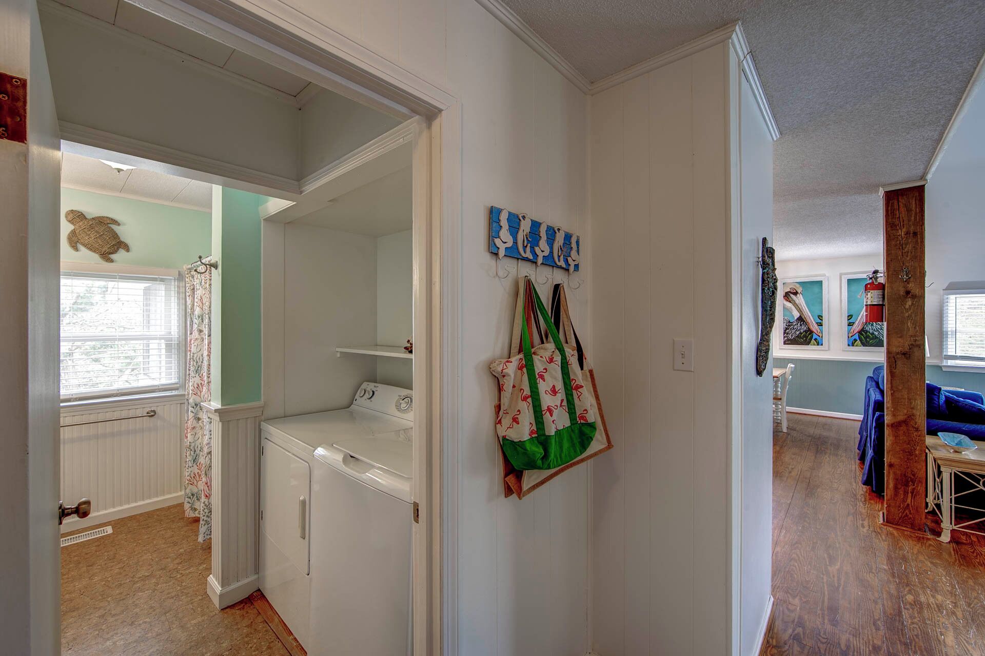 A laundry room with a washing machine, a drying rack, and a wall-mounted drying rack.