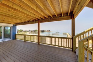 Une terrasse en bois offrant une vue sur la plage et l’océan.