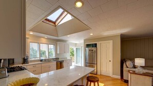 Una cocina amplia con una isla grande, un tragaluz y vistas al exterior.