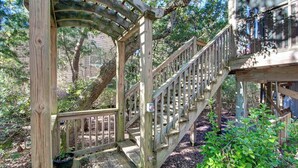 A wooden staircase leading up to a covered area surrounded by trees. - Charlotte's Place - Ocracoke Island (Ocracoke)
