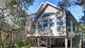 A two-story house with a balcony, wooden deck, and a large window. - Charlotte's Place - Ocracoke Island (Ocracoke)