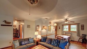 A cozy living room with a sofa, coffee table, and a dining area with a table and chairs. - Cole Bin - Ocracoke Island (Ocracoke)
