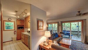 A cozy room with a wooden desk, a chair, a sofa, and a window overlooking greenery. - Cole Bin - Ocracoke Island (Ocracoke)