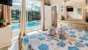 Une chambre dotée d’un grand lit, d’une télévision, d’une commode et donnant sur une piscine extérieure.
