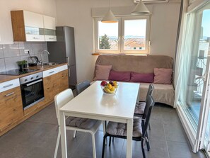 Une cuisine moderne avec un coin repas, un canapé et une vue par la fenêtre.