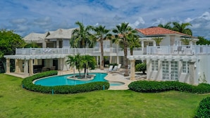 A large, two-story building with a swimming pool, palm trees, and a white exterior. - Luxury 2-level villa in Punta Cana (Punta Cana)