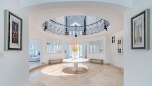 A spacious, well-lit atrium with a central white table, surrounded by white walls and large windows. - Luxury 2-level villa in Punta Cana (Punta Cana)