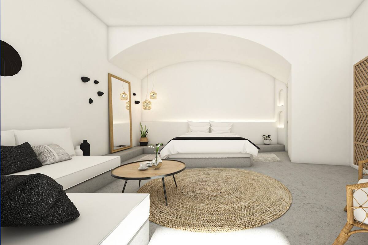 A modern, minimalist bedroom with a large bed, bedside tables, a round coffee table, and a wicker chair.