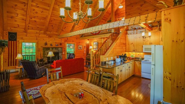 A cozy cabin interior with a dining area, kitchen, and living room.
