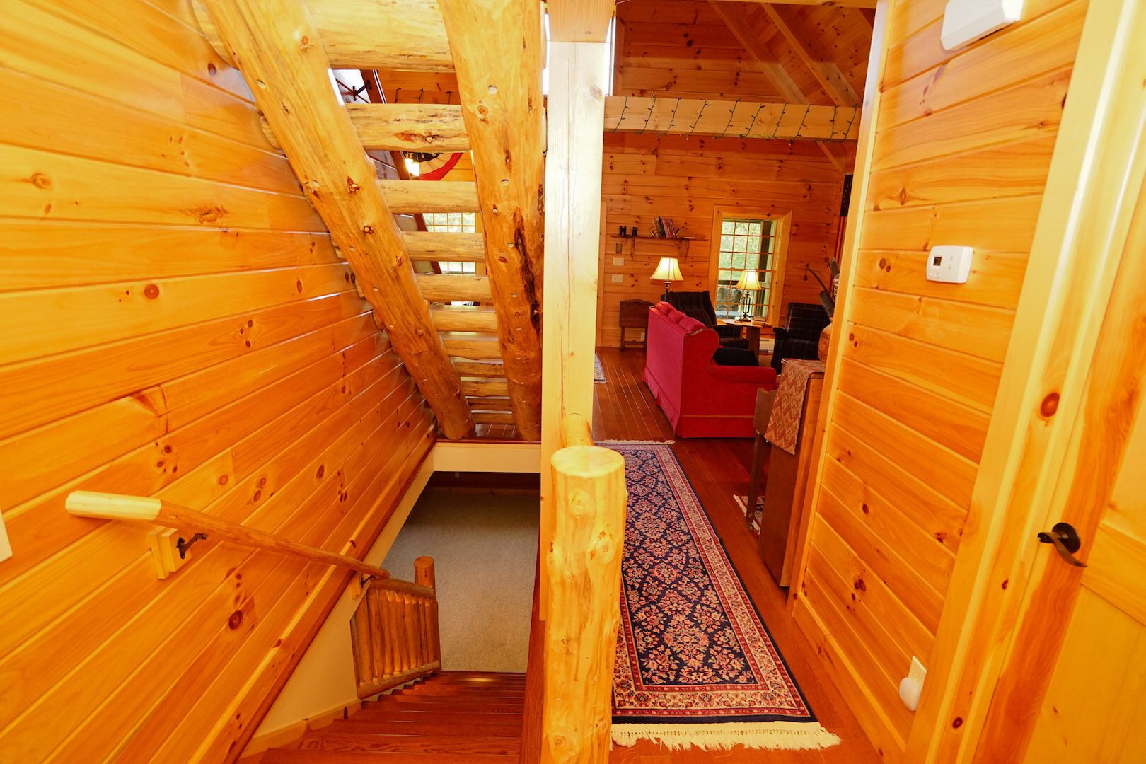 A wooden interior with a staircase leading to a living area.