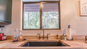A kitchen with a double sink, wooden countertop, and a window with blinds. - Sugar Pine Retreat - A/C & Pool Access (Camp Connell)