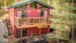 A red cabin with a balcony, a chimney, and a sign indicating a fireplace. - Sugar Pine Retreat - A/C & Pool Access (Camp Connell)