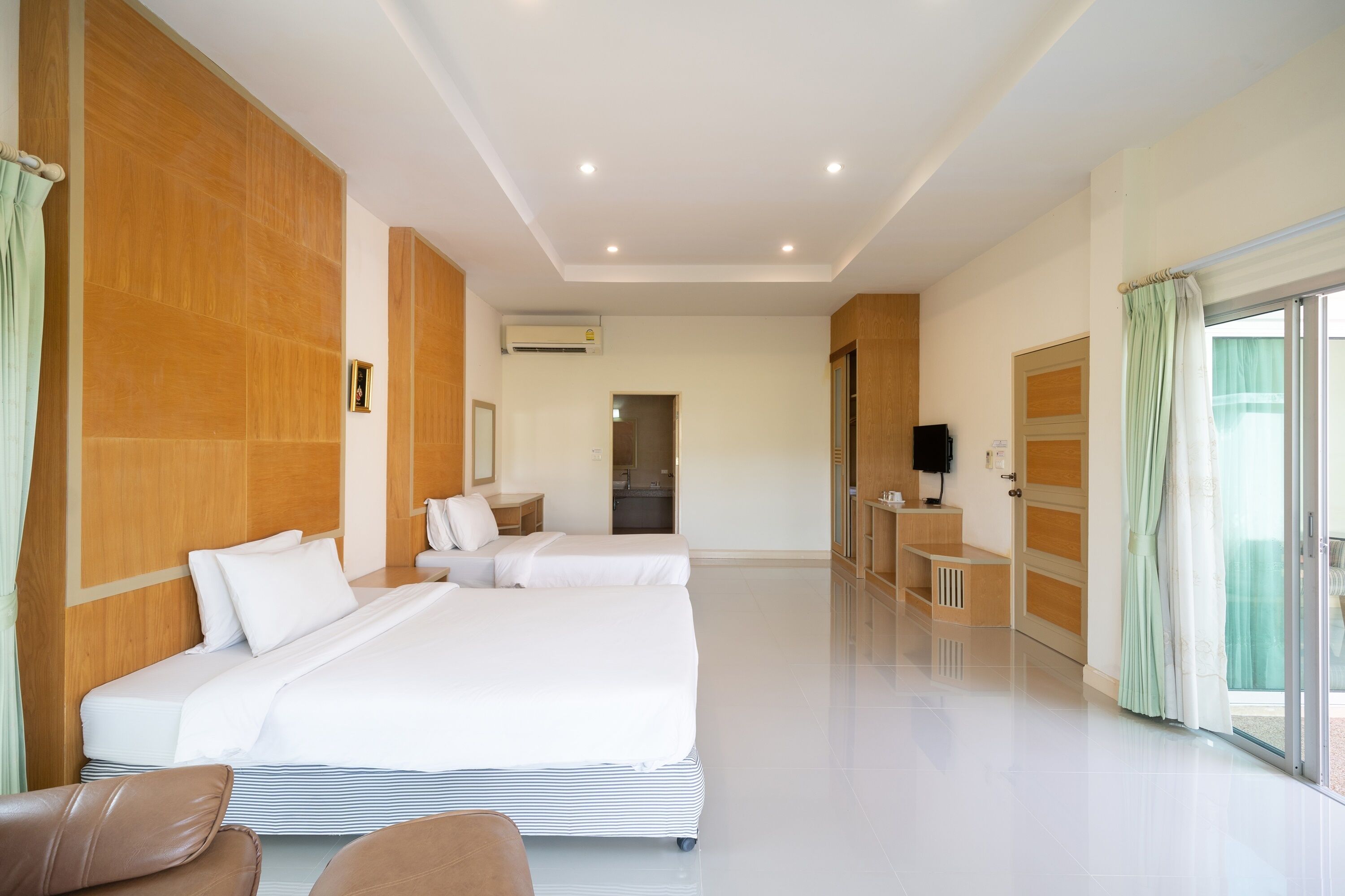 A modern hotel room with a large bed, a desk, and a bathroom in the background.