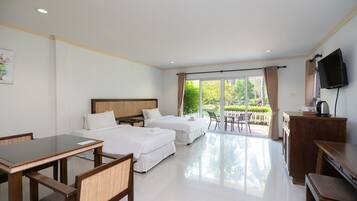 A hotel room with two beds, a dining table, chairs, a TV, and a view of the outdoors.