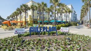 A sign for a wine walkabout event at a coastal location with palm trees and outdoor seating. - Gulf view, private beach, community pool, walk to shops and restaurants! (Santa Rosa Beach)