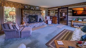 A cozy living room with a stone fireplace, a comfortable sofa, and a television. - Far Horizons #416 (Gatlinburg)