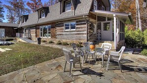 A log cabin with a stone patio, outdoor seating, and a covered porch. - Far Horizons #416 (Gatlinburg)