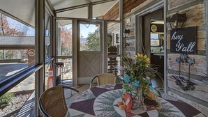 A cozy patio area with a table set for dining, a wicker chair, and a decorative vase with flowers. - Far Horizons #416 (Gatlinburg)