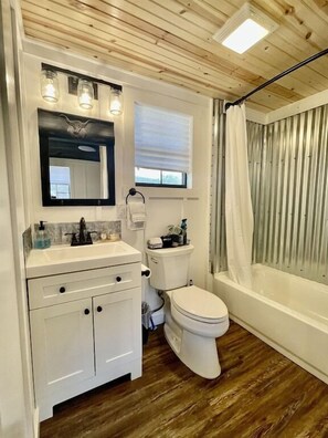 Tina con regadera, secadora de cabello, toallas 