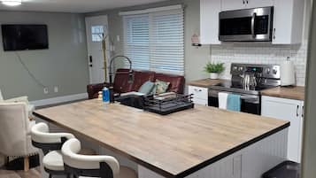 Una taula de menjador i una illa a la cuina