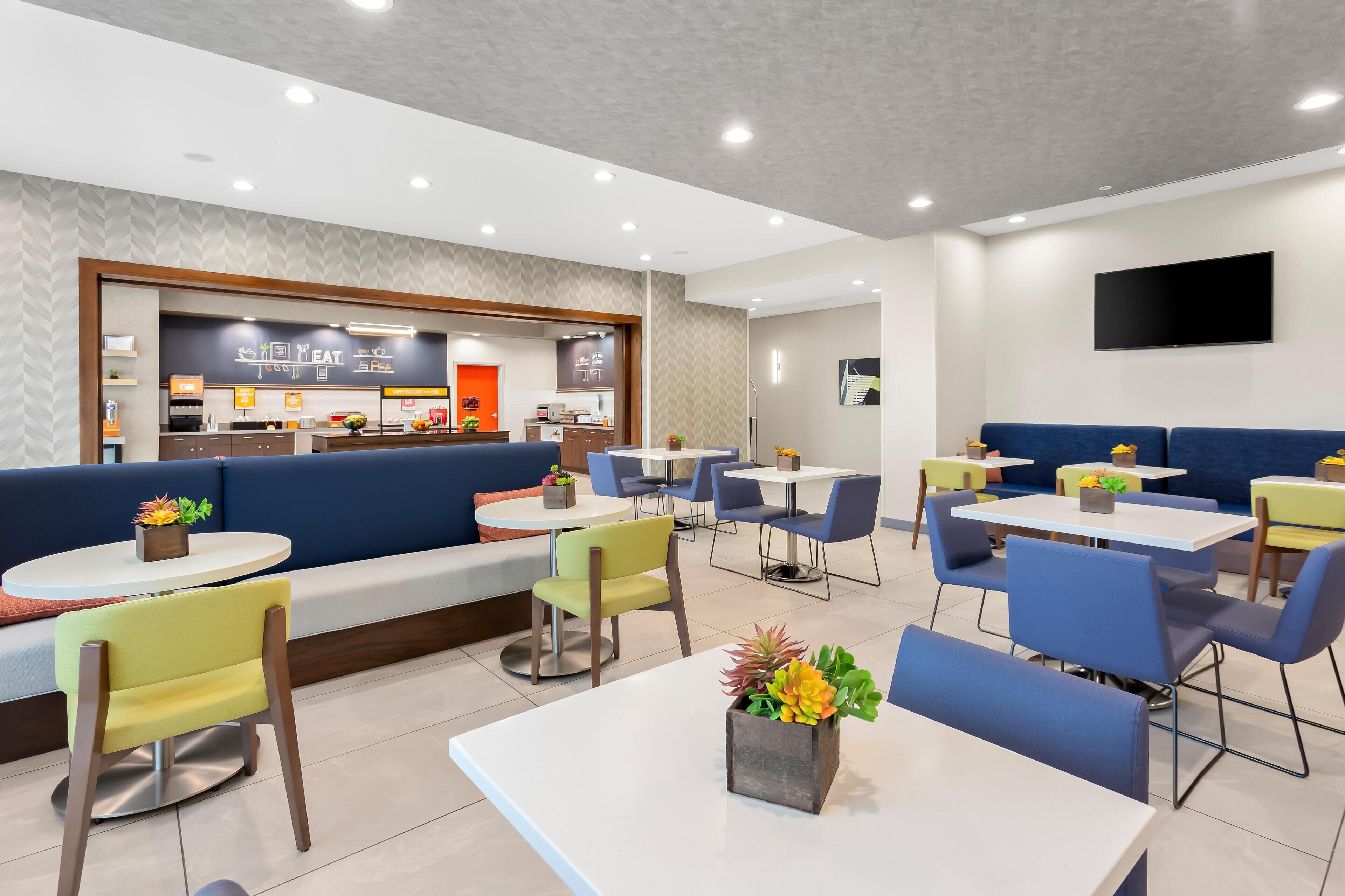 A modern restaurant with a counter, seating area, and tables.