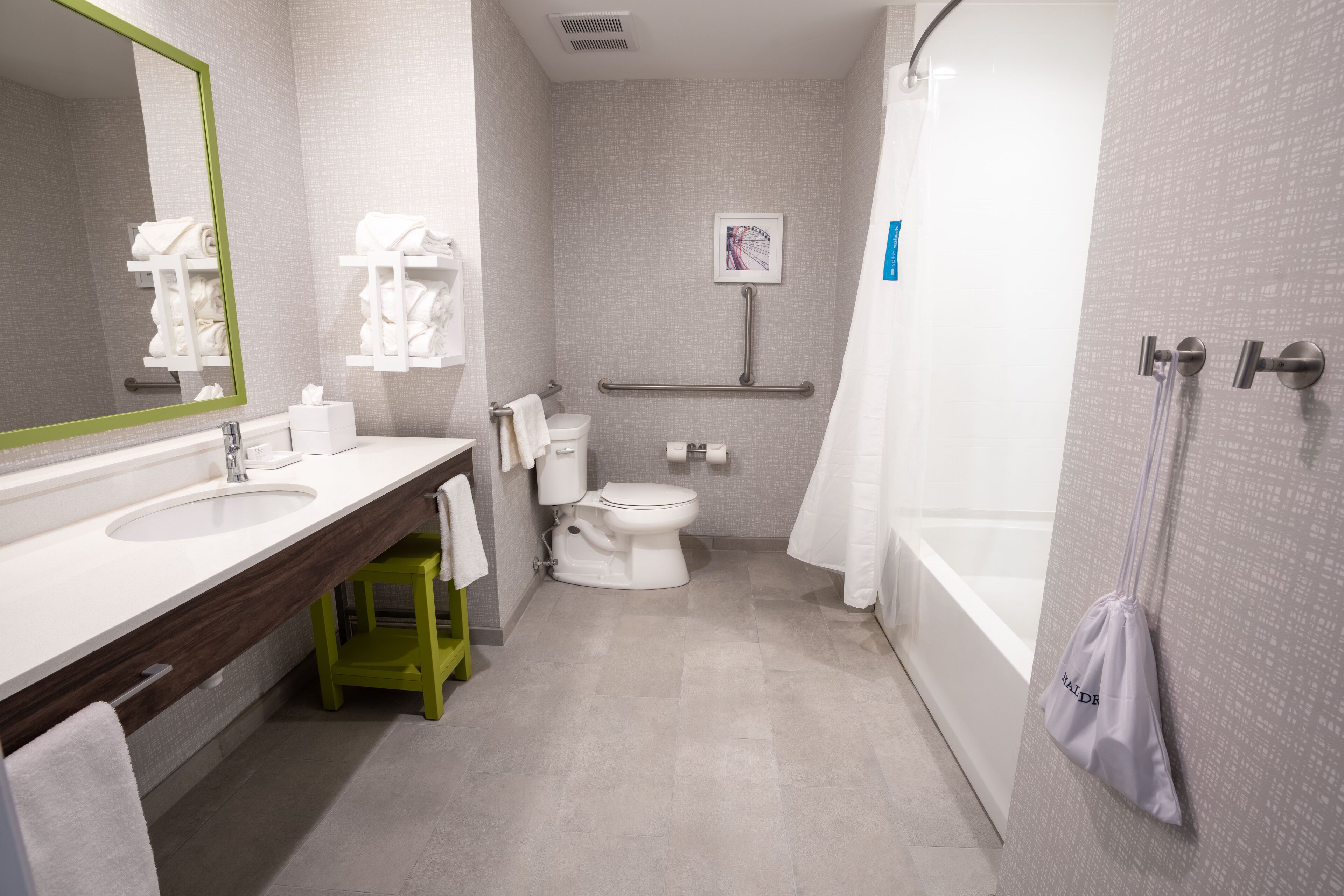 Un baño moderno con un espejo grande, dos lavamanos, un inodoro y una zona de ducha.