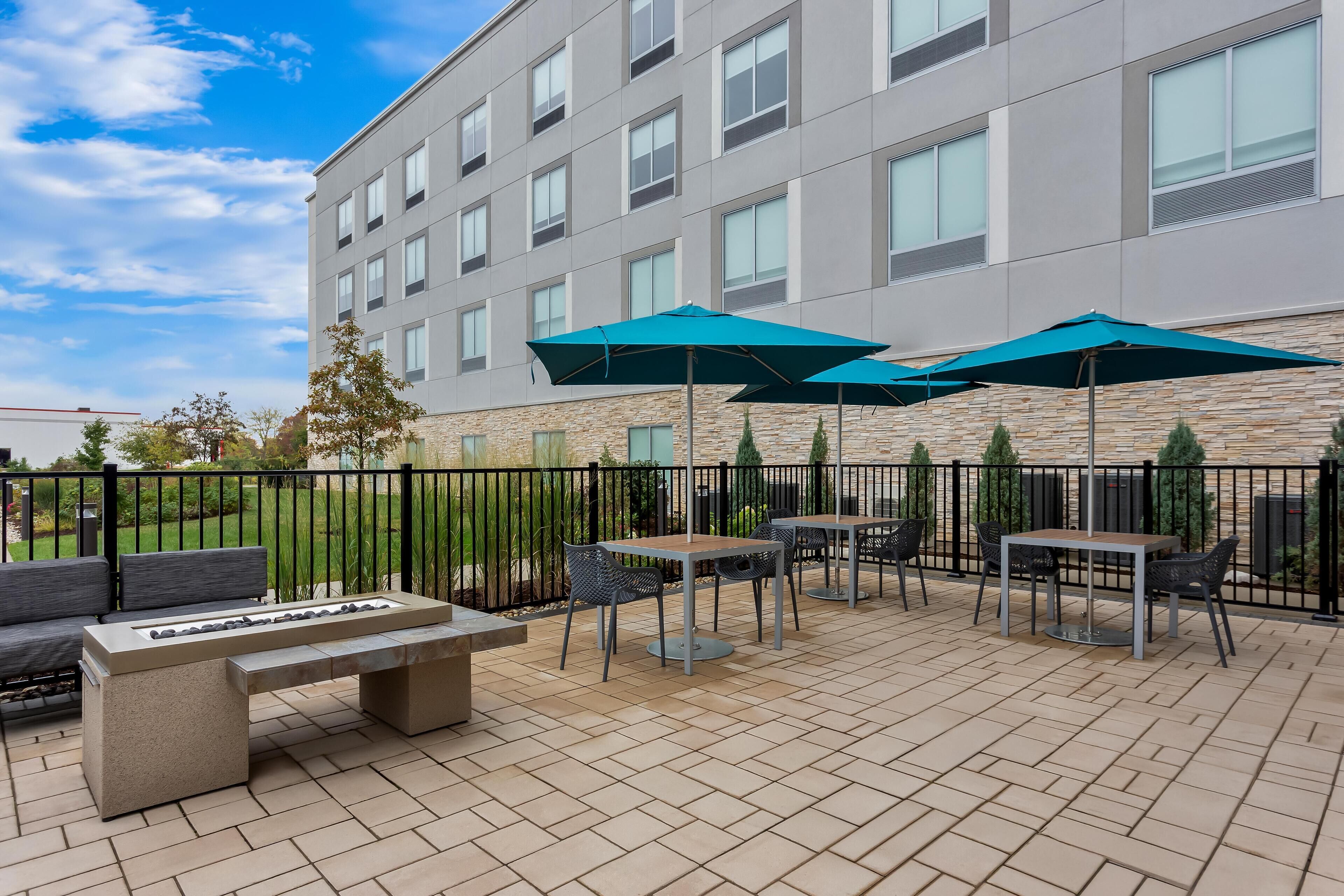 An outdoor patio with seating, tables, and umbrellas.