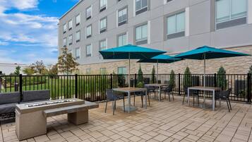An outdoor patio with seating, tables, and umbrellas.