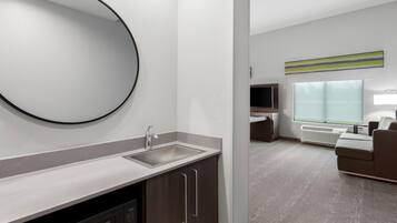 A modern bathroom with a sink, mirror, and cabinet.