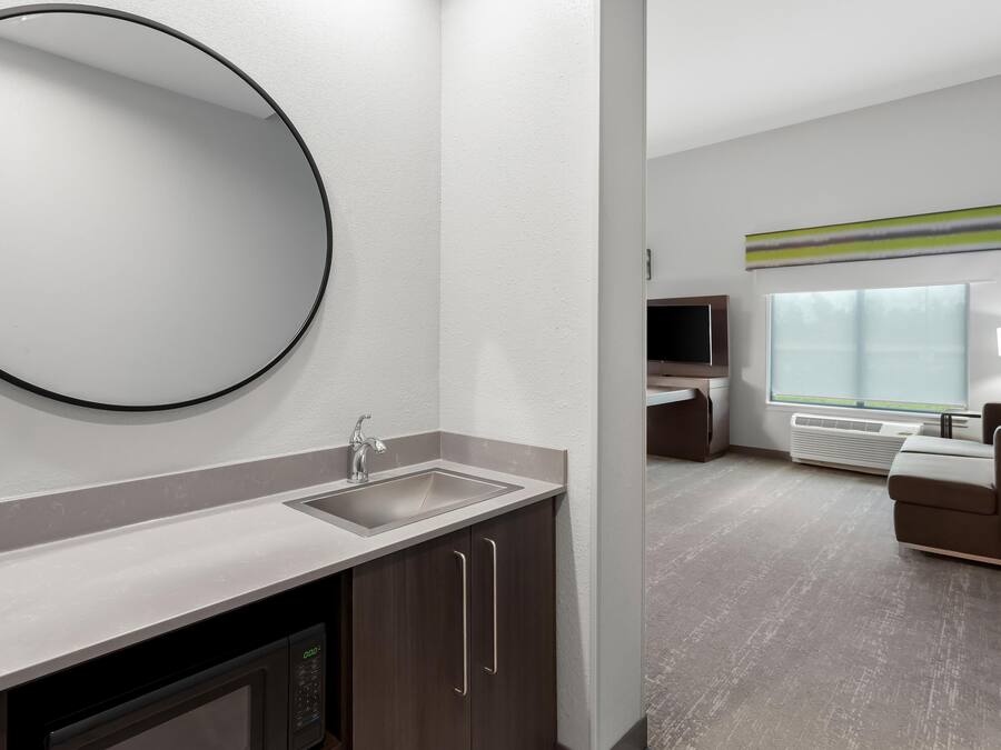 A modern bathroom with a sink, mirror, and cabinet.