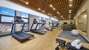 Una palestra moderna con tapis roulant, cyclette e una rastrelliera per pesi.