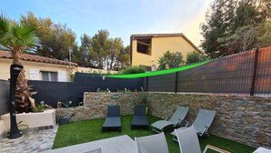 A backyard with a stone wall, a small pool, and lounge chairs. - House Bormes les Mimosas 100 m from shops and 200 m from the beach on foot (Bormes-les-Mimosas)