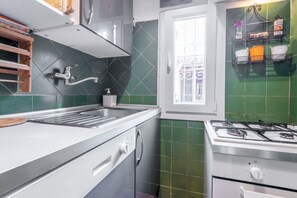 Une cuisine équipée d’une cuisinière à gaz, d’un évier et d’une fenêtre donnant sur un beau paysage.