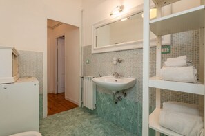 Une salle de bain équipée d’un lavabo, d’un miroir et d’un porte-serviettes.