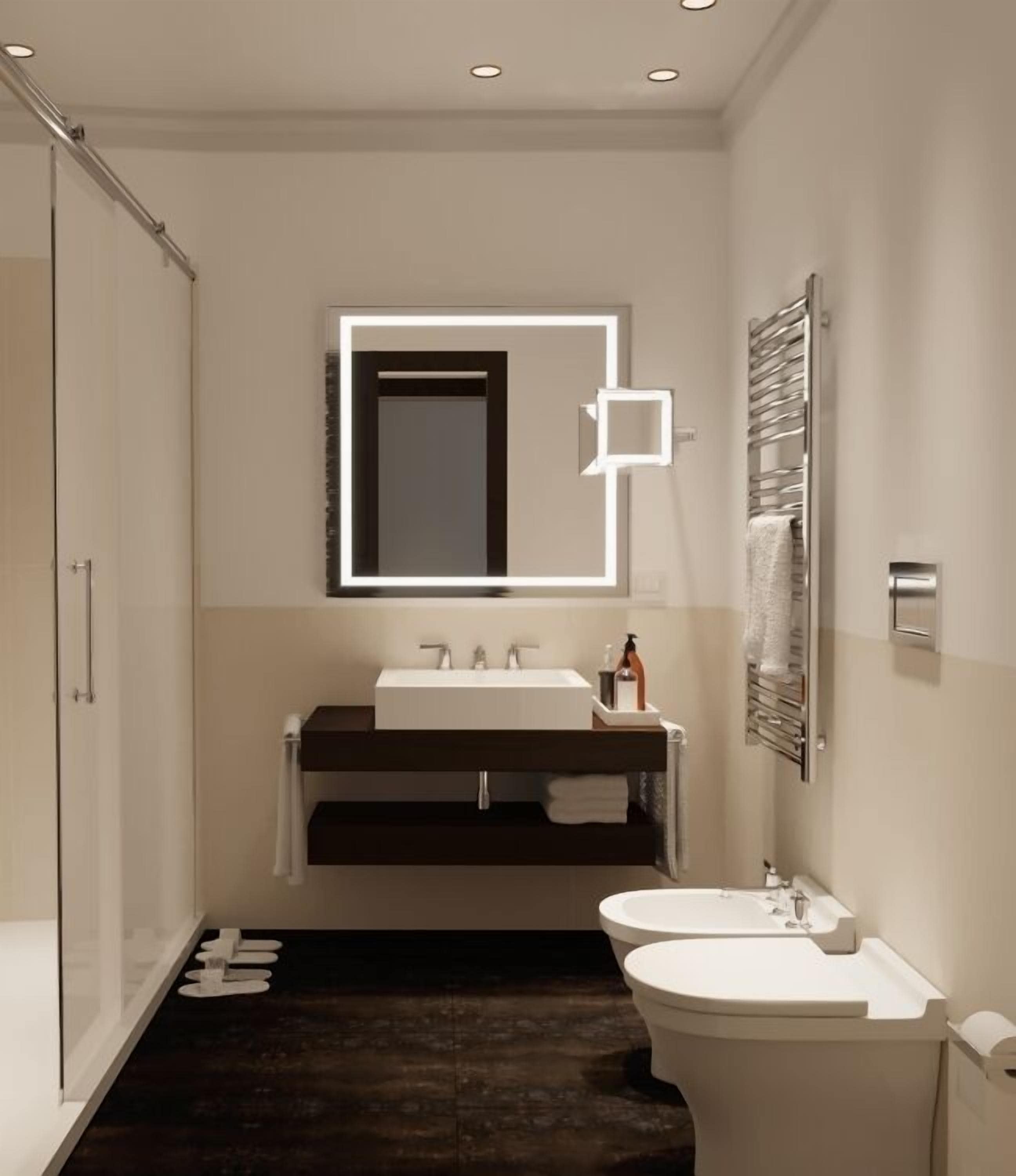 Une salle de bain moderne avec un grand miroir, un meuble-lavabo en bois foncé, un lavabo blanc et un autre lavabo sur pied, séparé.