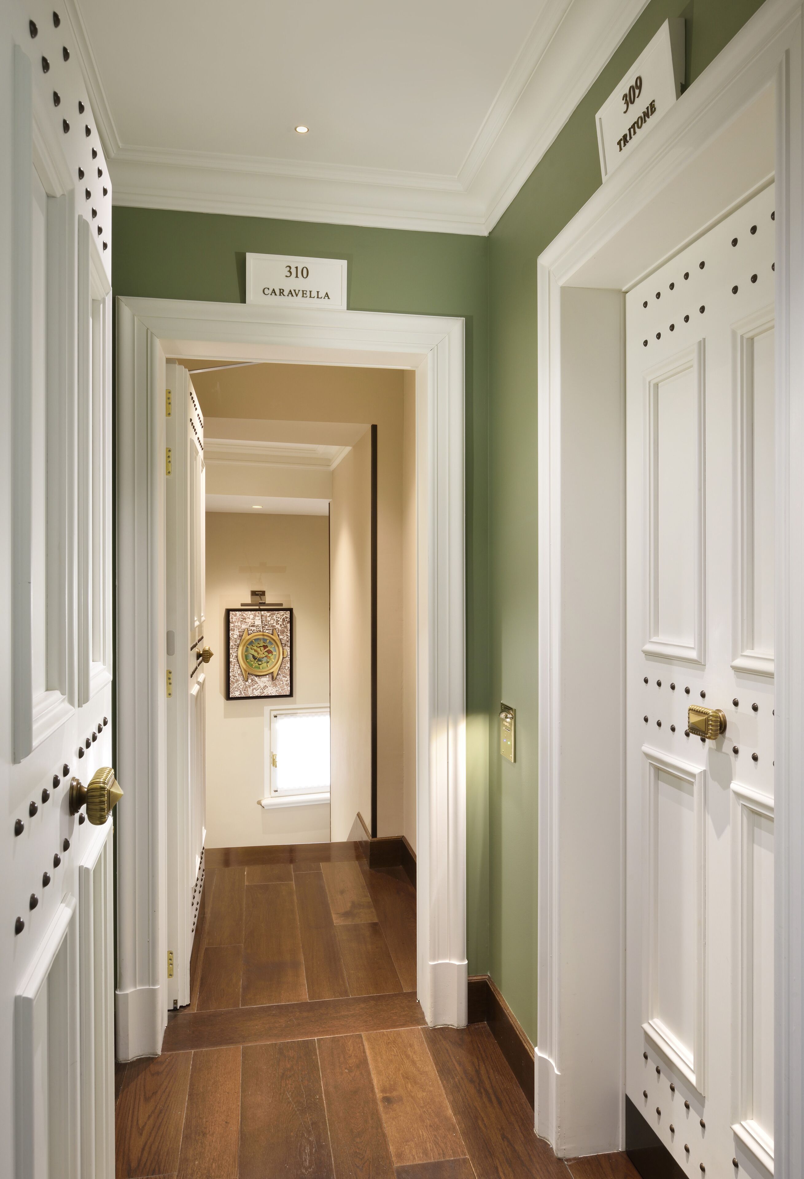 A hallway with a sign reading "310 Caravella" and a door labeled "309 Trion."
