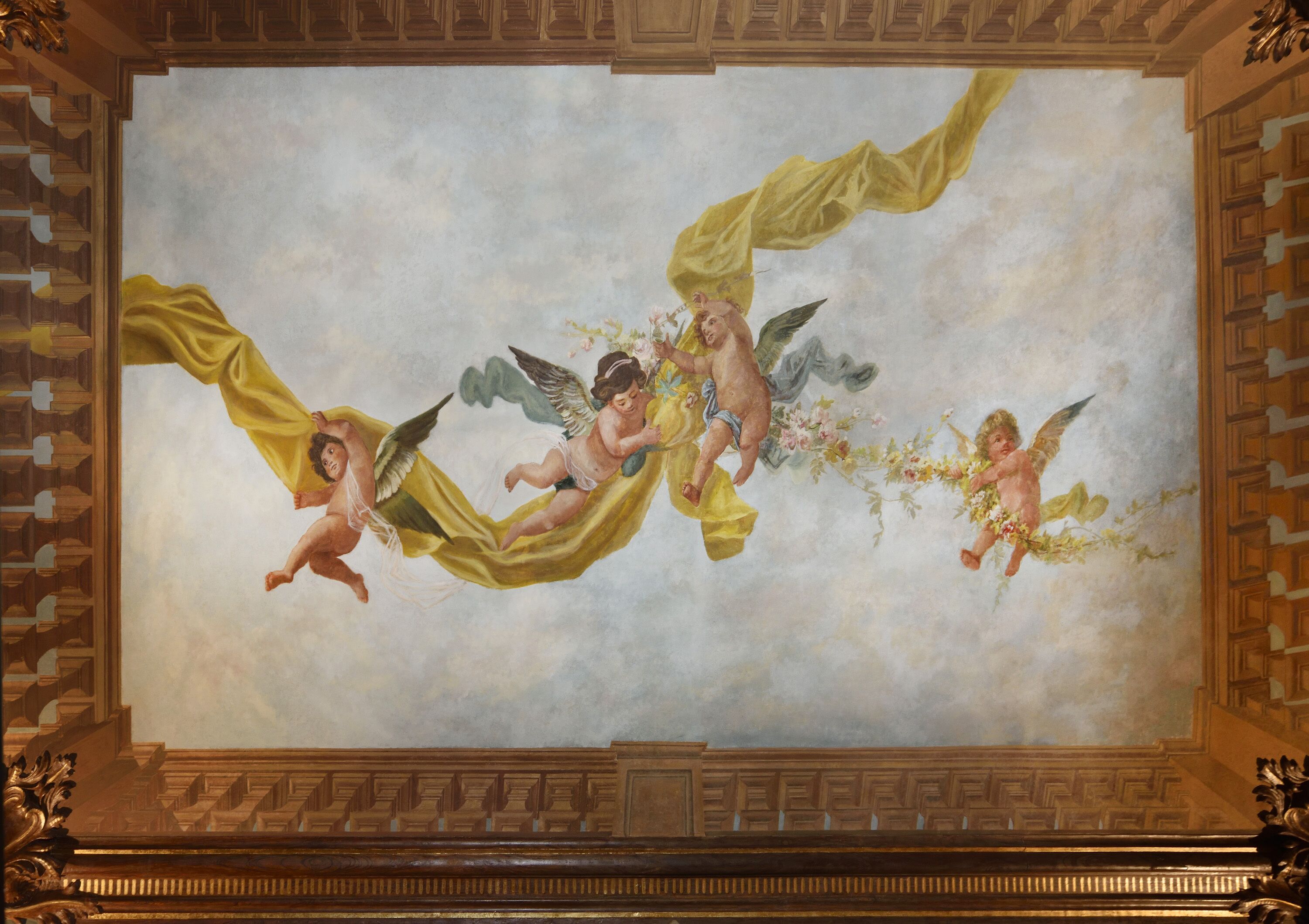 Ein Wandgemälde von Cherubs an einer Decke mit aufwendiger Holzvertäfelung.