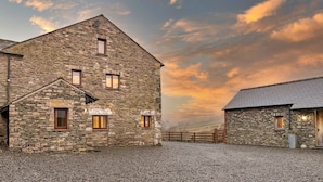 A stone building with multiple windows and a gravel driveway. - Bretherdale Barn (Bretherdale)