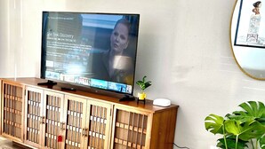 A wooden entertainment center with a flat-screen TV displaying a Star Trek Discovery episode.