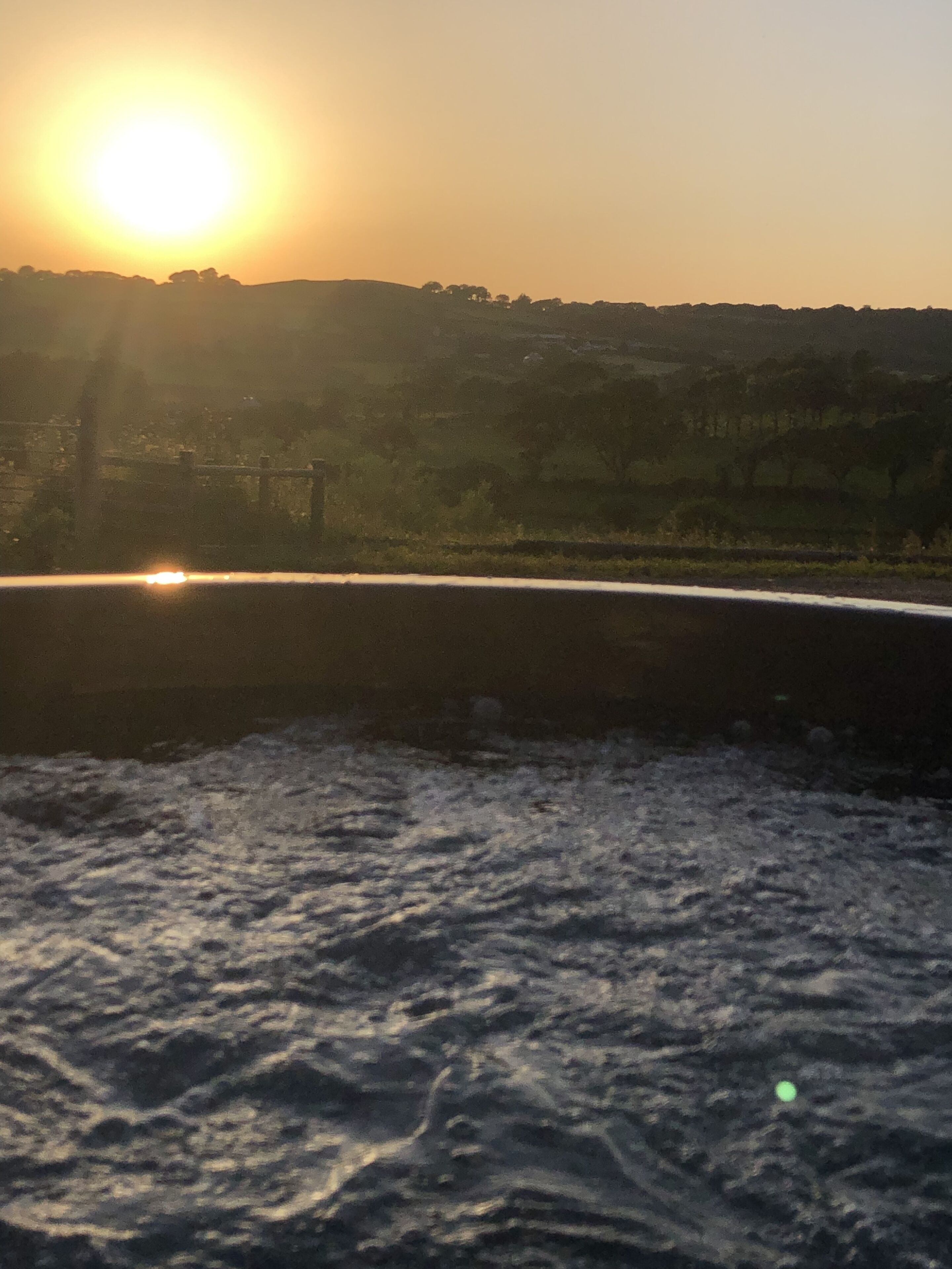 A sunset over a body of water with a distant shoreline.