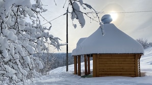 En stuga av trä med ett snötäckt tak och en klar himmel.