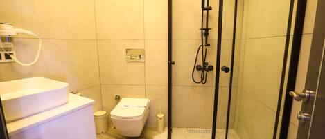 A modern bathroom with a toilet, bidet, and shower.