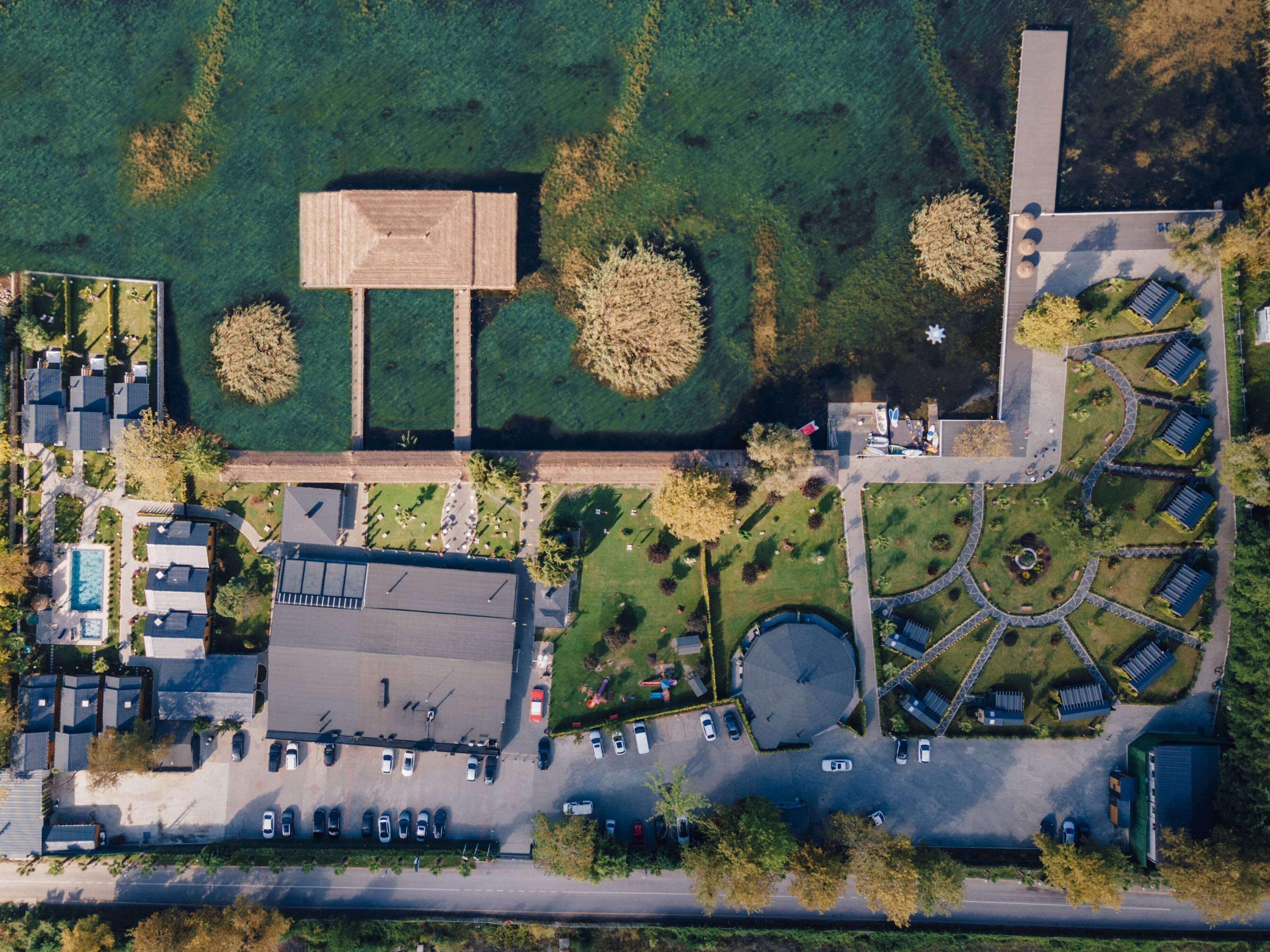 An aerial view of a residential area with a large building, parking lots, and green spaces.