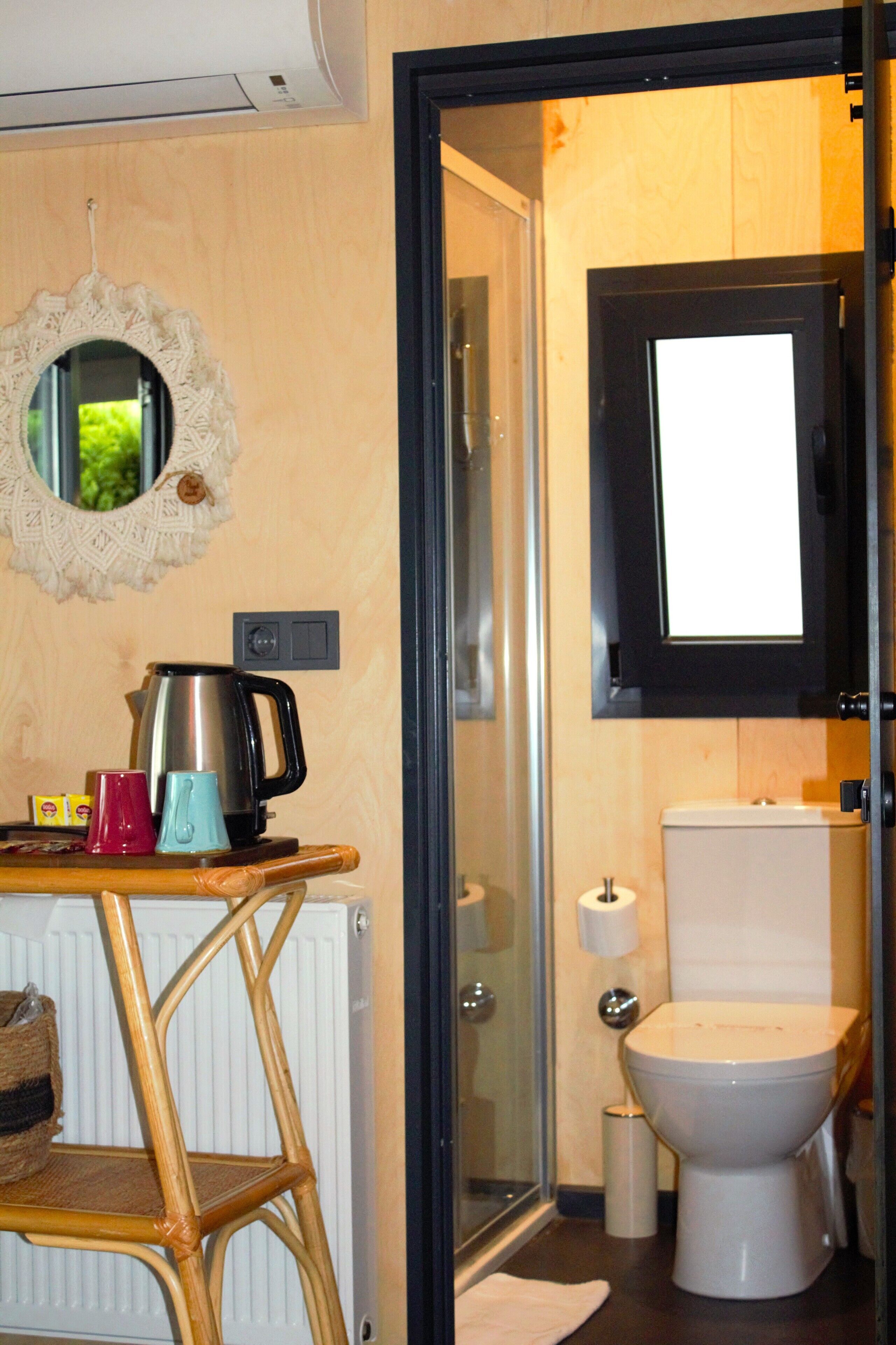 A bathroom with a toilet, a mirror, a sink, and a radiator.
