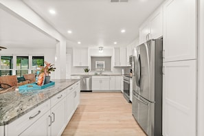 Enjoy cooking in this well-equipped kitchen with a refrigerator, oven, and granite countertop.