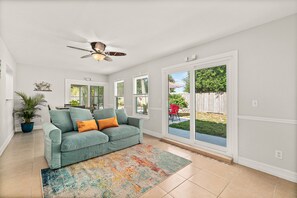 Relax in this inviting living area with a sofa, ceiling fan, and colorful rug.